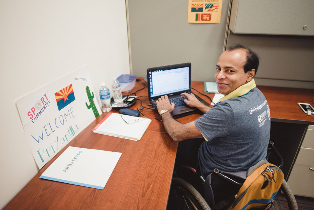 Priyantha Peiris, an executive member of the Sri Lanka Paralympic Committee, works from his desk at Ability360 in Phoenix, Ariz.
